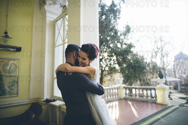 Newlywed couple embracing at terrace