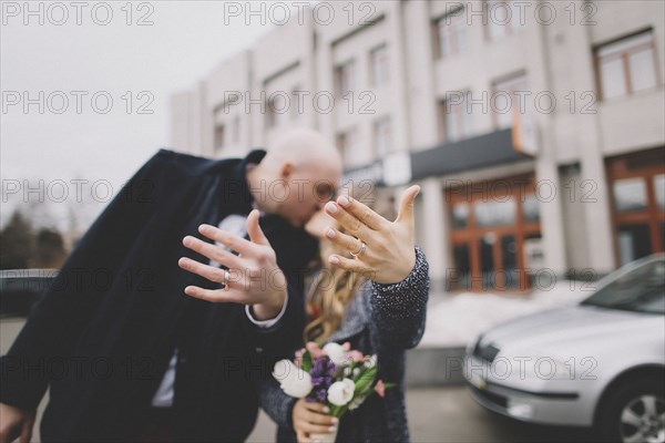 Newlywed couple kissing on street