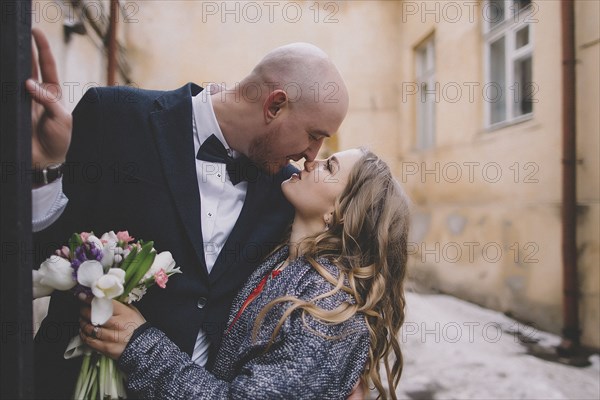 Newlywed couple kissing on street