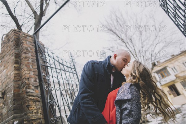 Newlywed couple kissing on street