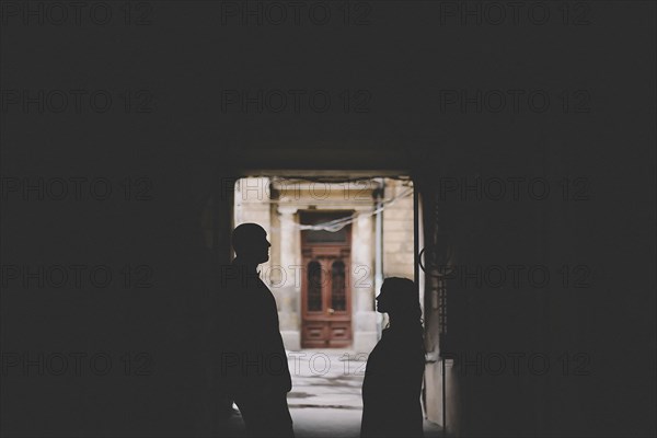 Silhouettes of newlywed standing in gate