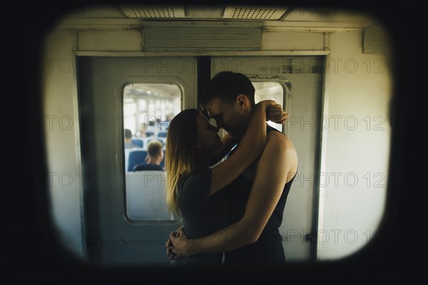 Young couple kissing in train