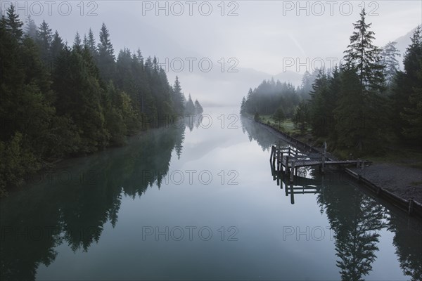 Austria, Plansee, Lake Plansee and wooden pier in fog at Austrian Alps