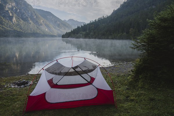 Austria, Plansee, Tent by lake Plansee in Austrian Alps at sunrise