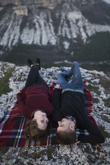 Ukraine, Crimea, Young couple lying down at plaid near canyon