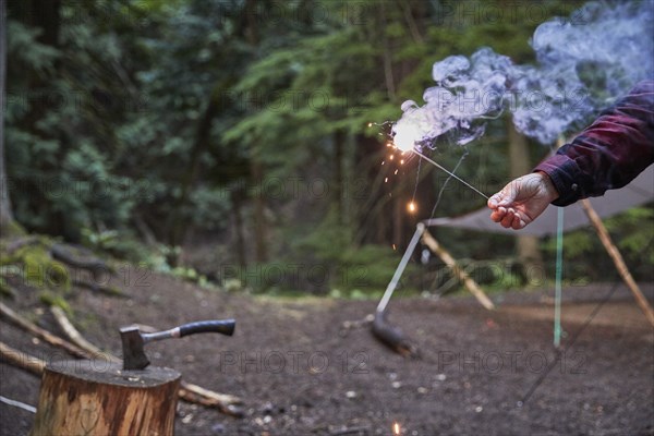 Orcas Island, Man holding sparkler at camping