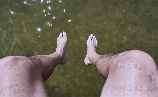 Man sitting above water