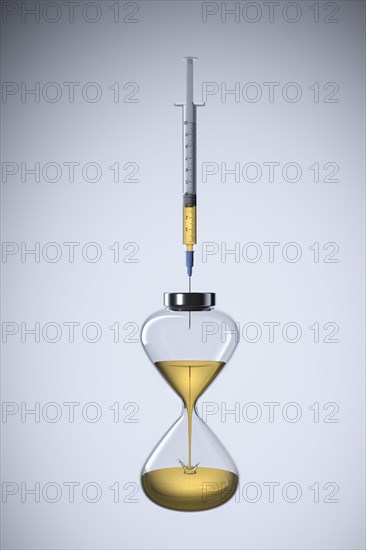 Studio shot of hourglass and syringe