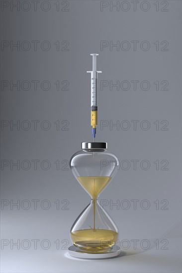 Studio shot of hourglass and syringe