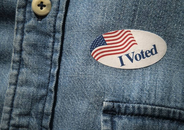 Close-up of I voted sticker on denim shirt