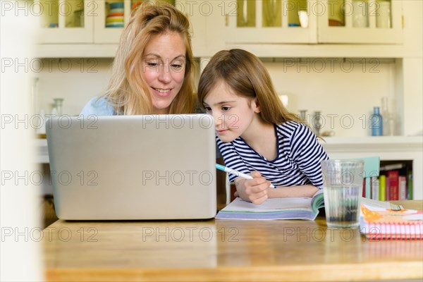 Mother and daughter looking at laptop