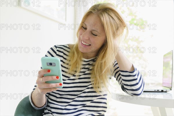 Smiling woman using smart phone