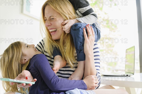 Children (4-5, 6-7) playing with mother