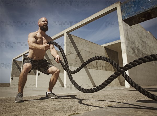 Man exercising with ropes