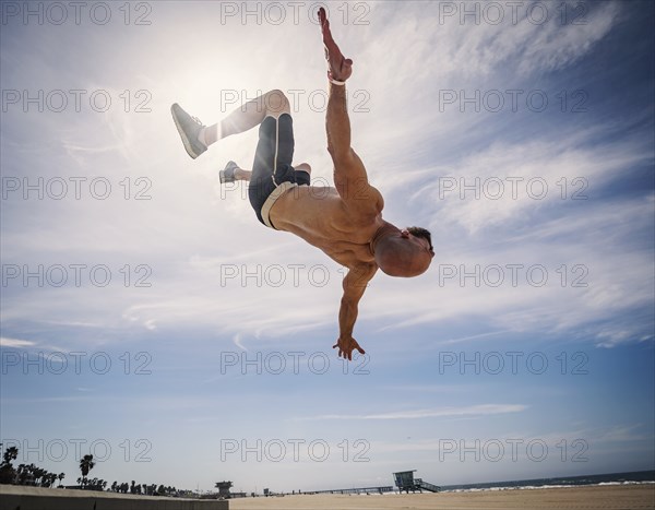 Muscular man exercising on beach