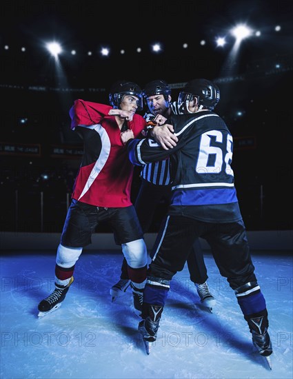 Referee separating fighting hockey players