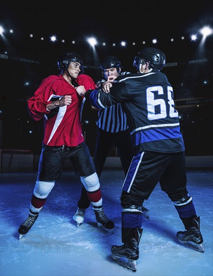 Referee separating fighting hockey players