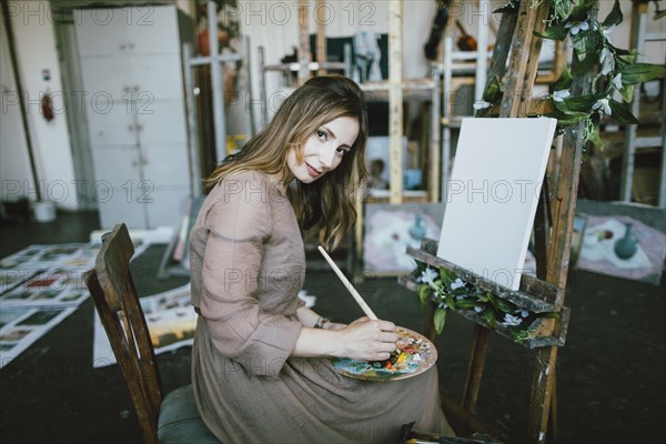 Woman painting on canvas in art studio