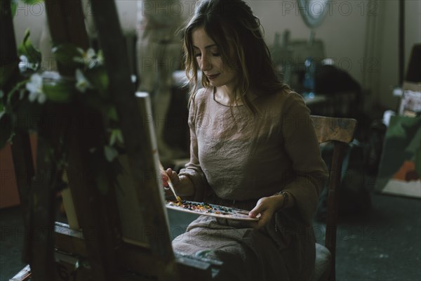 Woman painting on canvas in art studio