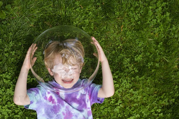 Boy wearing bubble outdoors to socially distance