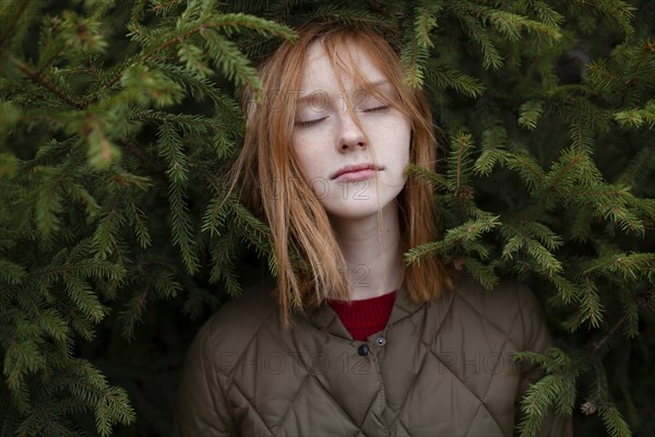 Portrait of young woman in foliage