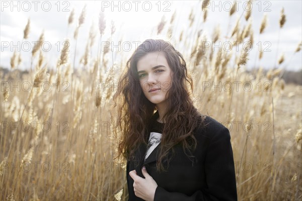 Russia, Omsk, Portrait of young woman in tall grass