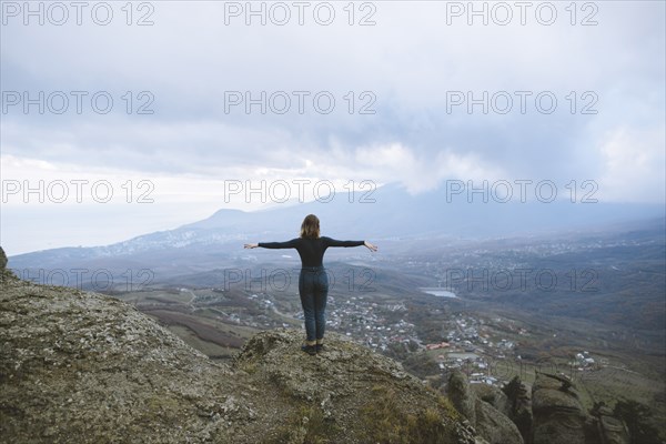 Ukraine, Crimea, Young woman looking at valley in Crimea mountains