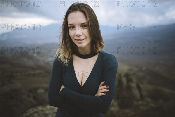 Ukraine, Crimea, Portrait of young woman with mountain valley in background
