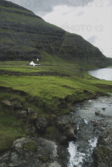 Denmark, Small church in green landscape with mountains and sea,