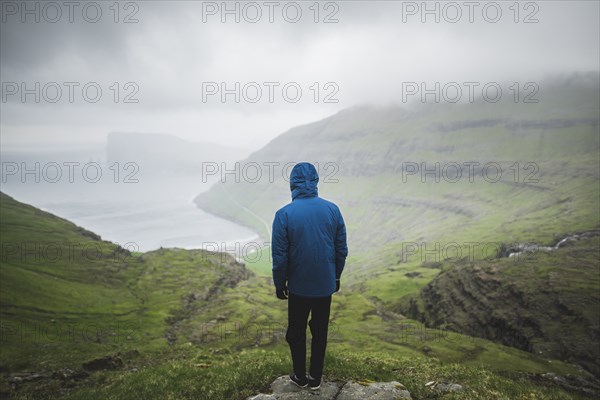Denmark, Man standing on cliff above sea and looking at view,