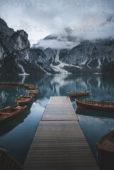 Italy, Wooden boats moored by pier at Pragser Wildsee in Dolomites,