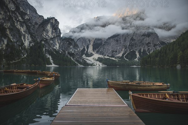 Italy, Wooden boats moored by pier at Pragser Wildsee in Dolomites,