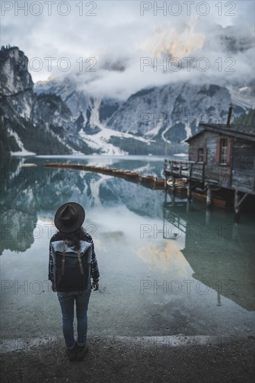 Italy, Woman standing by Pragser Wildsee in Dolomites,