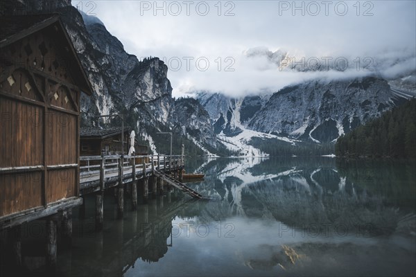 Italy, Wooden houses and pier at Pragser Wildsee in Dolomites,