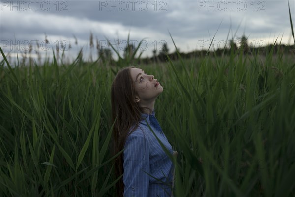 Russia, Omsk, Young woman in tall grass