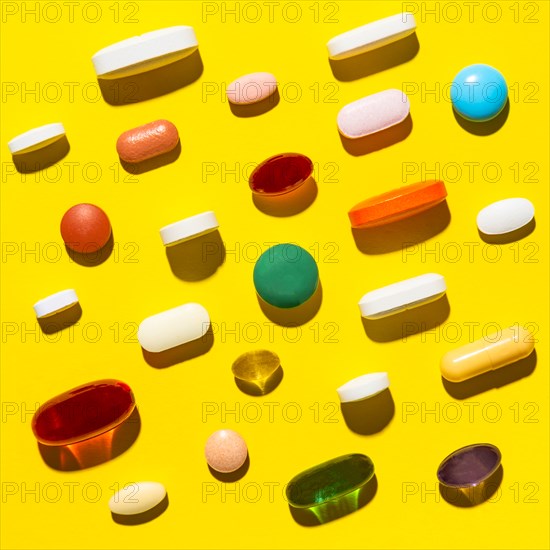 Pills and capsules on yellow