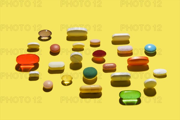 Pills and capsules on yellow