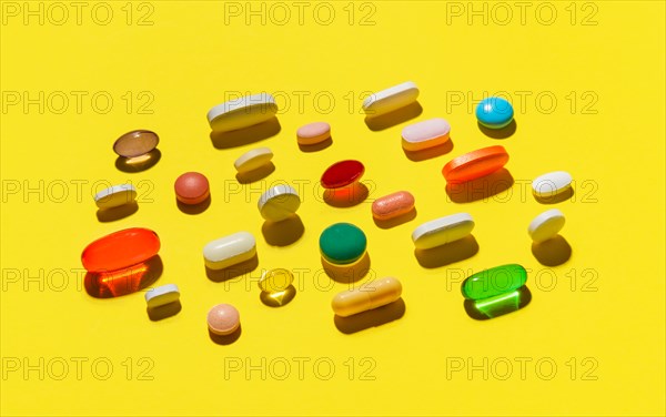 Pills and capsules on yellow