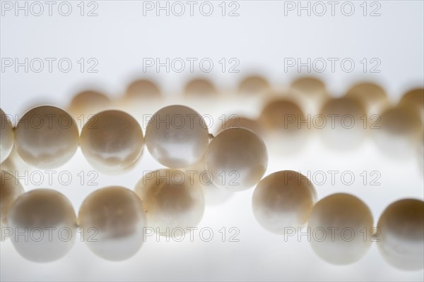 Close up of pearl necklace on white