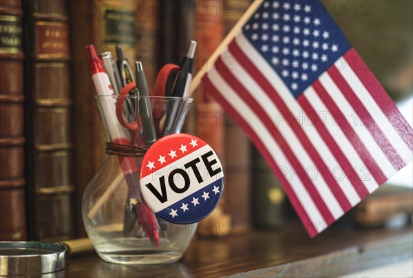 American flag, vote pin in pencil jar,