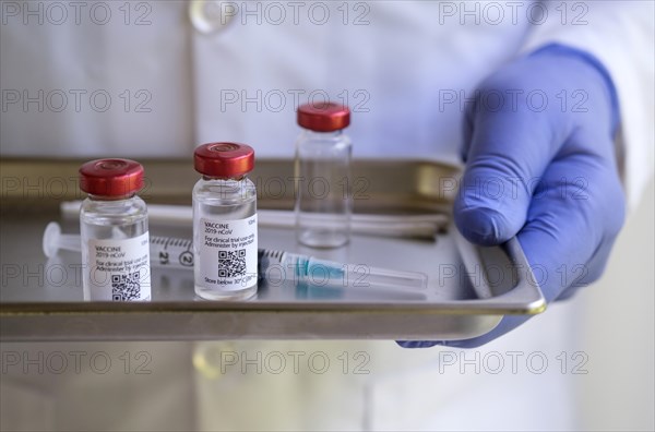 Person wearing glove holding medicine tray