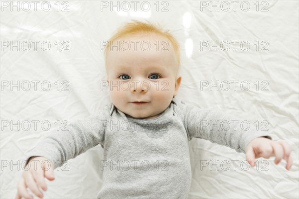 Portrait of baby boy lying on bed