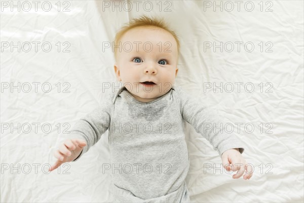 Portrait of baby boy lying on bed