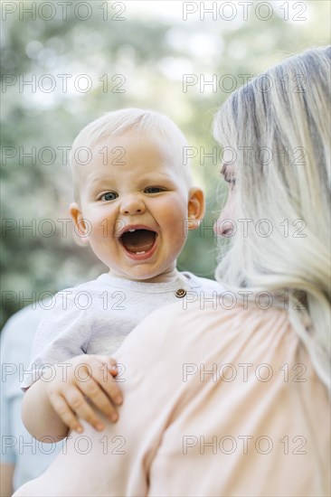 Baby boy laughing in mothers arms