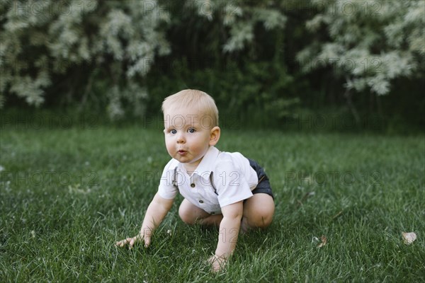 Baby boy crawling in grass