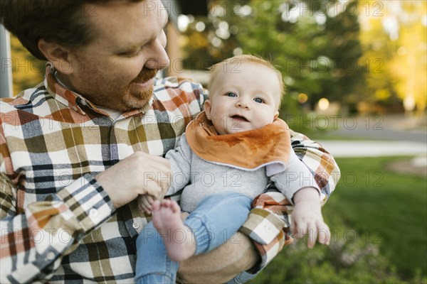 Father carrying baby boy outdoors