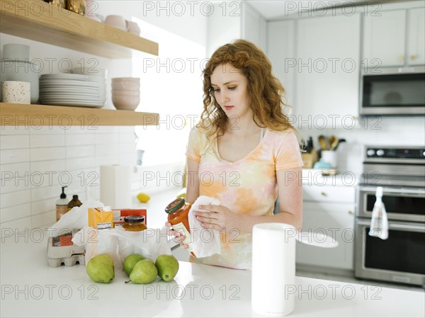 Woman cleaning jar in kitchen