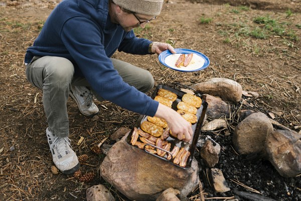 Man cooking breakfast during camping