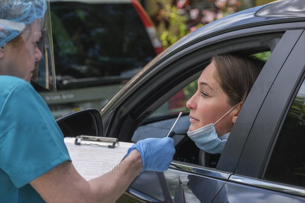 Woman in car receiving covid-19 test