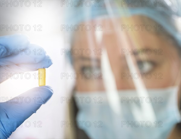 Female scientist holding pill